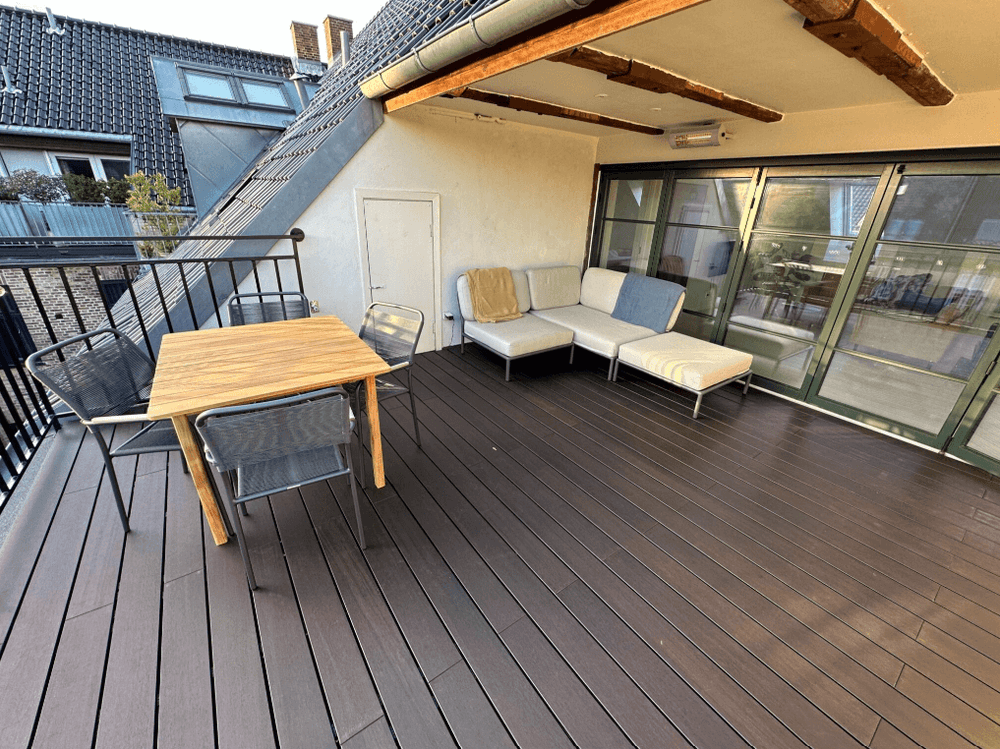 Dachterrasse mit edlen Bambus-Terrassendielen in dunkelbraunem Espresso-Ton, hochwertiger Outdoor-Lounge und Esstisch aus Holz. Die pflegeleichten, wetterfesten Bambusdielen sorgen für eine moderne und nachhaltige Gestaltung im Außenbereich. Ideal für Balkon, Terrasse oder Garten.