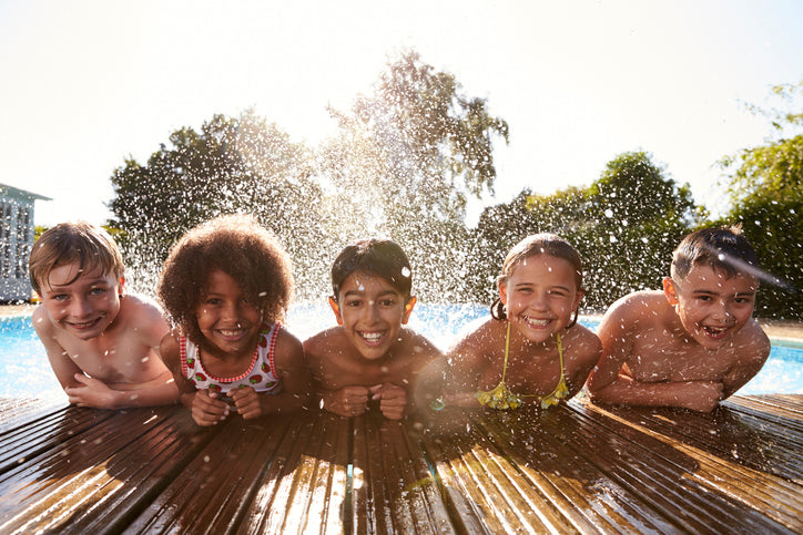 Kinder auf Terrassendielen am Pool.