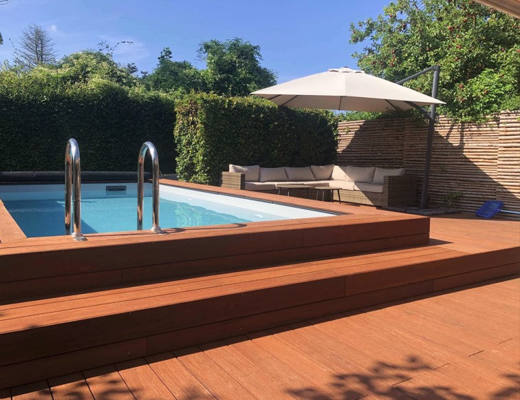 Großzügige Bambusterrasse in coffee mit Pool und Lounge.