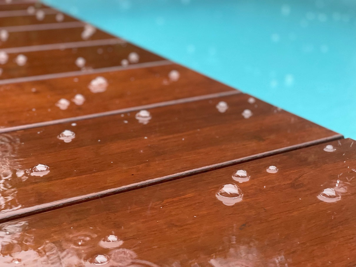 Die wetterfesten Terrassendielen im Regen am Pool. 