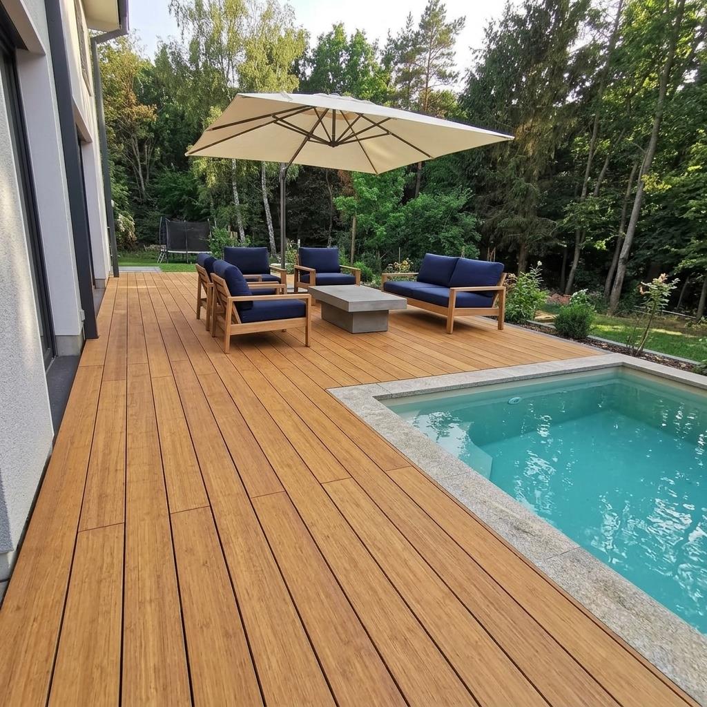 Moderne Poolterrasse aus Desaro Bambus-Terrassendielen mit Loungemöbeln und Sonnenschirm im Garten.