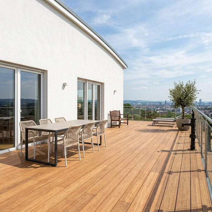 Großzügige AMBOOO-Terrasse mit Esstisch, Liegen, Glasgeländer und weitem Blick über die Stadt.