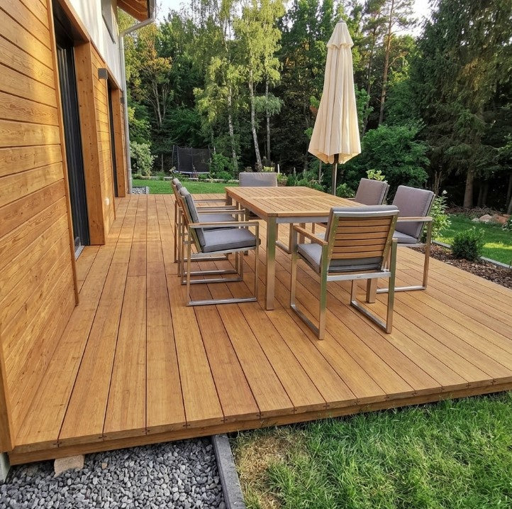 Großzügige Terrasse aus Bambus-Terrassendielen mit Gartenmöbeln an einem Wohnhaus – langlebiger und natürlicher Terrassenbelag für den Außenbereich.