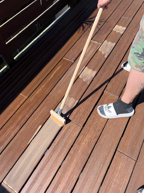 Terrassenöl wird mit einem Flächenstreicher gleichmäßig auf die Dielen einer Bambusterrasse aufgetragen, um die Oberfläche zu pflegen und vor Witterungseinflüssen zu schützen.